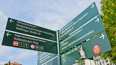 Wegweiser auf einem Hochschul-Campus.