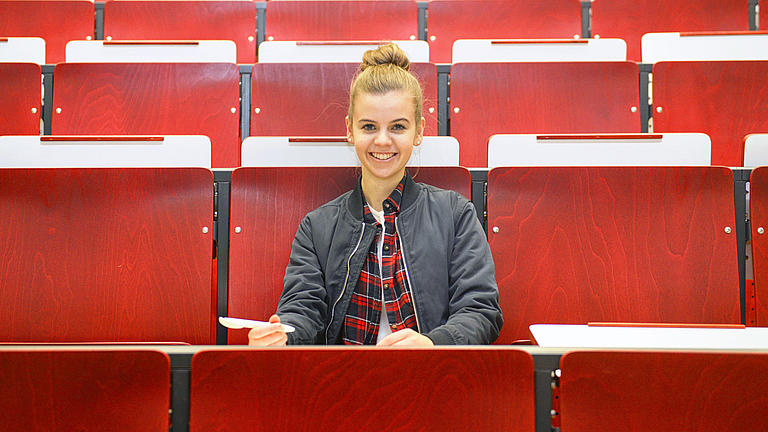 Eine Studentin sitzt in einem Hörsaal.