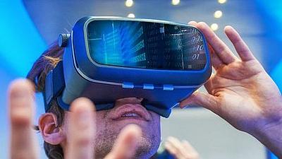 Ein junger Mann sieht durch eine VR-Brille