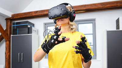 Eine junge Frau mit einer VR-Brille auf dem Kopf.