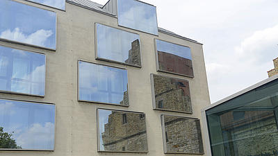 Ein altes Gebäude spiegelte sich in den Fenstern eines modernen Gebäudes.