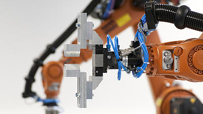 Ein orangefarbener Roboterarm mit silbergrauer Halterung.