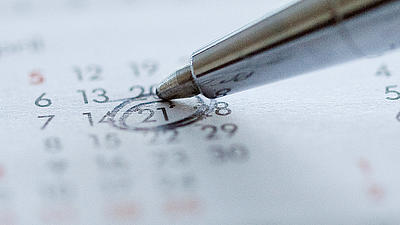 Ein Kugelschreiber umkringelt ein Datum in einem Kalender.