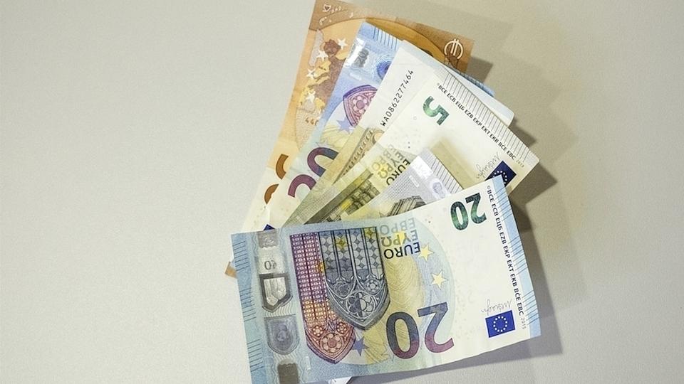 Mehrere 5-, 10- und 20-Euro-Scheine liegen nebeneinander auf einer Unterlage.