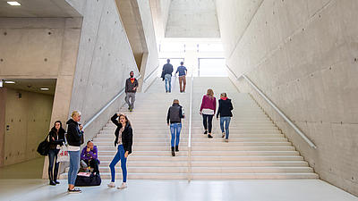 Foto eines modernen Treppenhauses einer Hochschule. Auch mit Bachelor und Master geht es Stufe für Stufe nach oben.