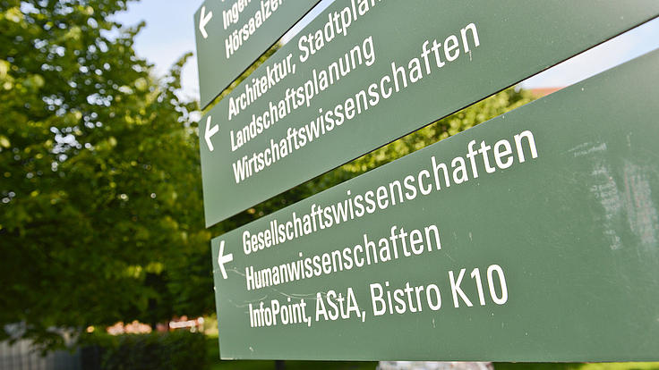 Blick auf Orientierungsschilder auf dem Campus der Universität Kassel.