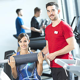 Zwei junge Menschen in einem Fitnessstudio.