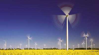 Auf einem Feld stehen viele Windräder.