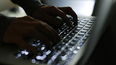 Zwei Hände tippen auf einer Laptop-Tastatur.