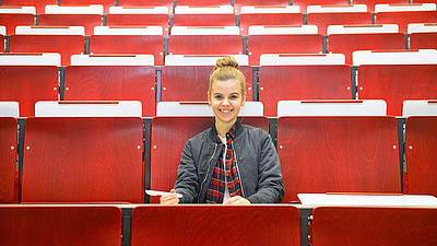 A female student sitting in a lecture hall.