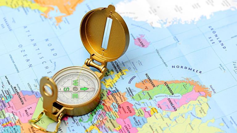 Ein Kompass liegt auf einer Landkarte.