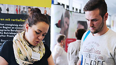 Zwei Studierende bei einer Info-Messe.