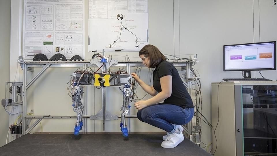 Eine junge Frau nimmt Einstellungen an einem Roboter vor.