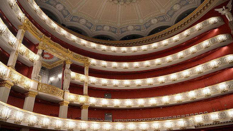 Blick auf die oberen prunkvollen und beleuchteten Balkone im Münchener Nationaltheater.