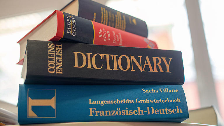 Verschiedene Wörterbücher die übereinander gestapelt sind.