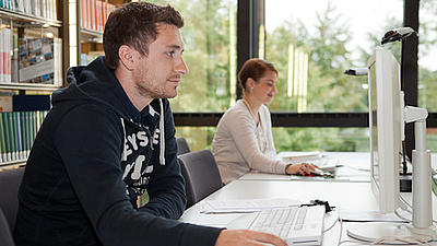 Zwei Studierende arbeiten am Rechner.