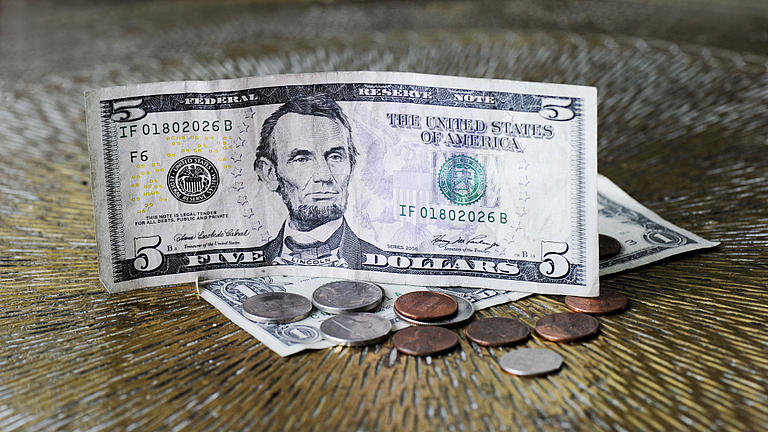 Ein Dollarschein und mehrere Münzen aus den USA.