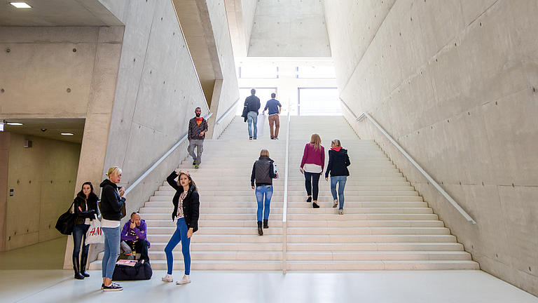 Foto eines modernen Treppenhauses einer Hochschule. Auch mit Bachelor und Master geht es Stufe für Stufe nach oben.