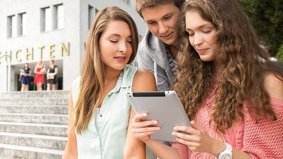 Studierende mit Tablet vor der Uni