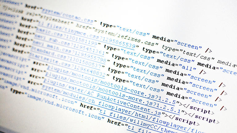 Nahaufnahme von einem Programmiercode, dargestellt auf einem Computermonitor. Zu sehen ist schwarze und blaue Schrift auf weißem Hintergrund.