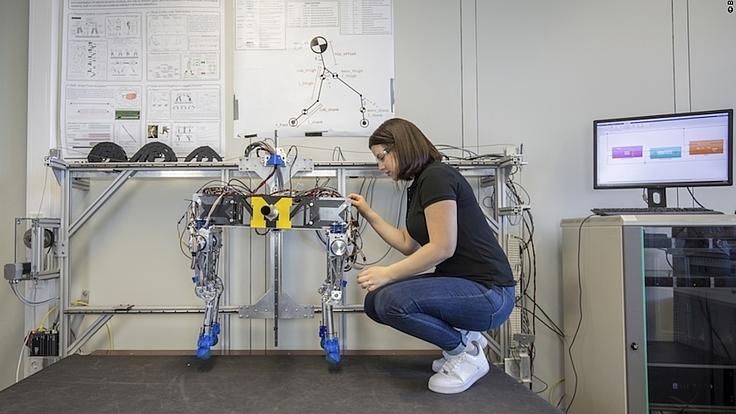 Eine junge Frau nimmt Einstellungen an einem Roboter vor.